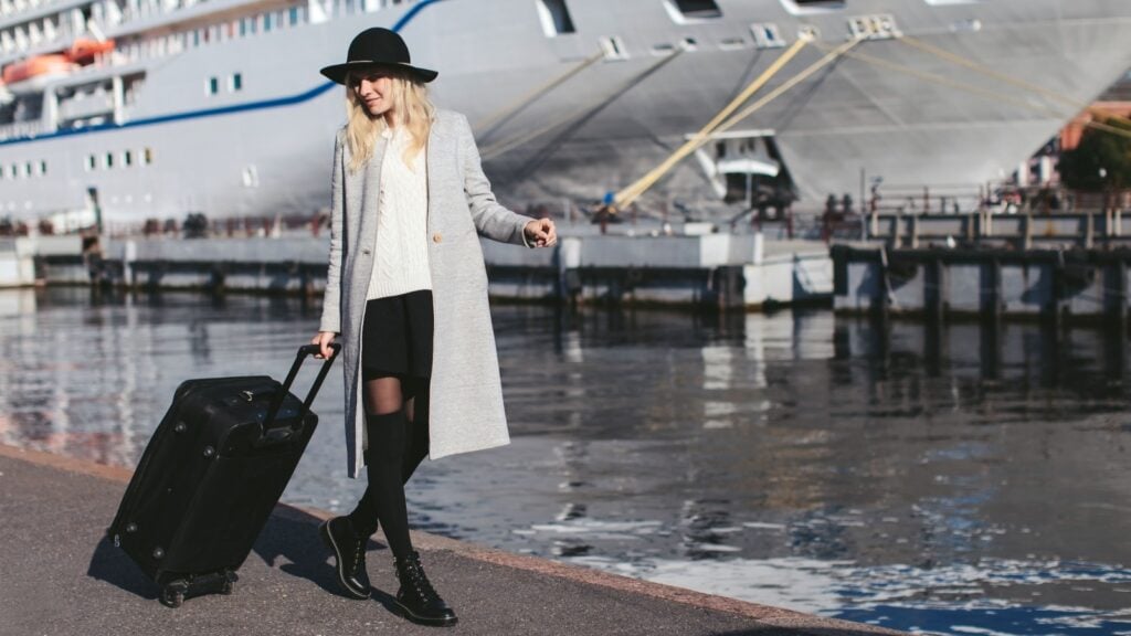 Traveler with suitcase arriving at cruise port before embarkation day