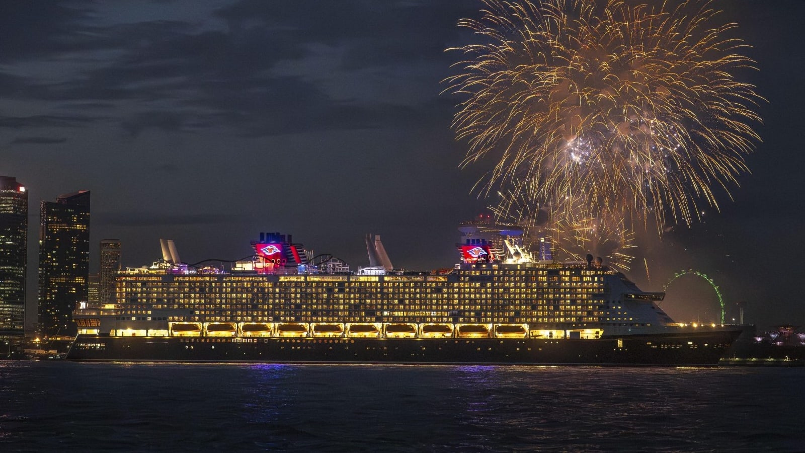 Disney Cruise Line ship at night with fireworks over the water
