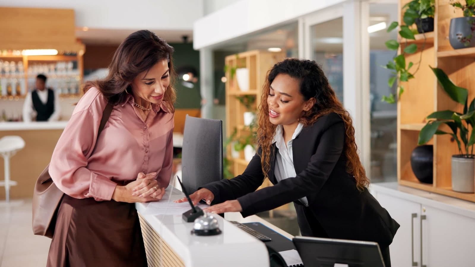Hotel guest speaking with front desk staff during check in at a modern hotel