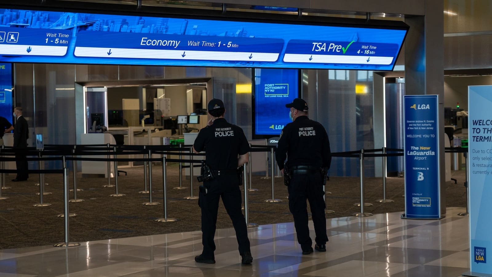 LaGuardia Airport security checkpoint with TSA PreCheck signage during travel disruption