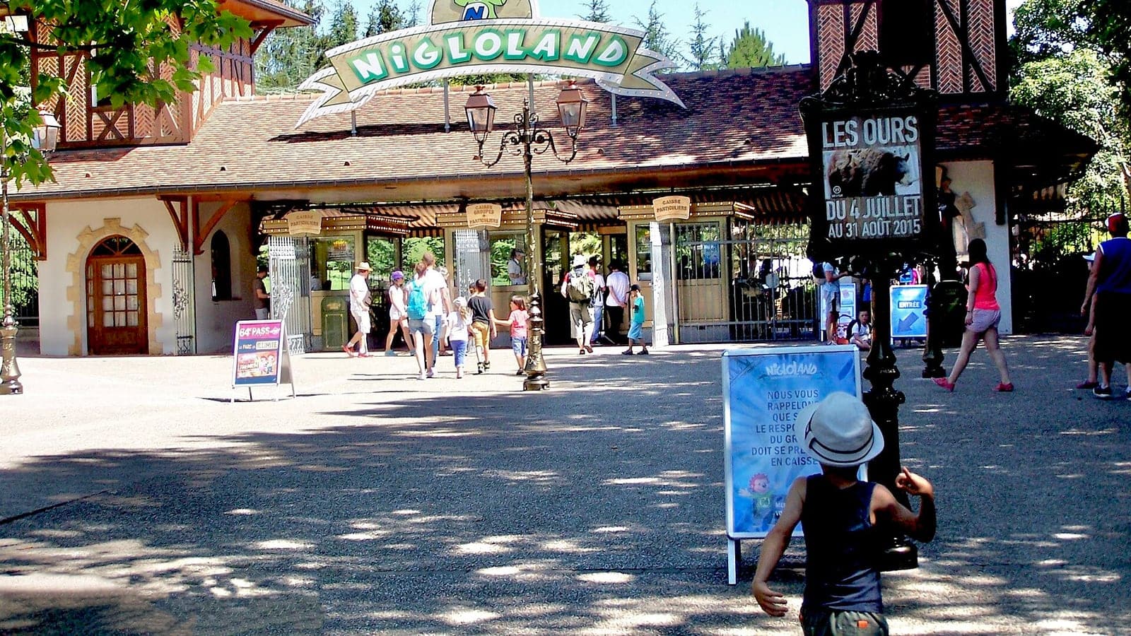 A beautiful view of the lush, green pathways and clean family-themed structures inside Nigloland theme park in France.