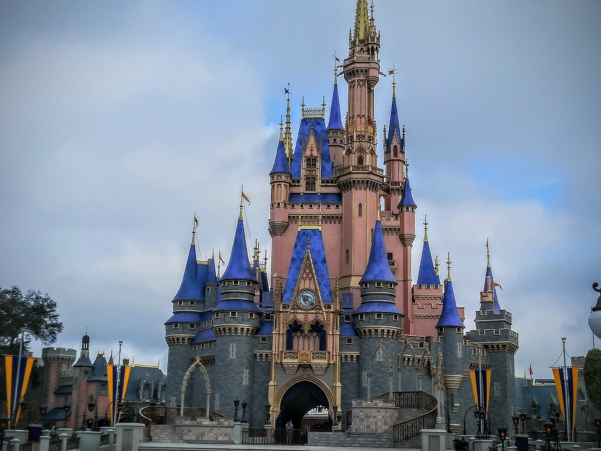 Cinderella Castle at Walt Disney World lit at dusk against a blue sky