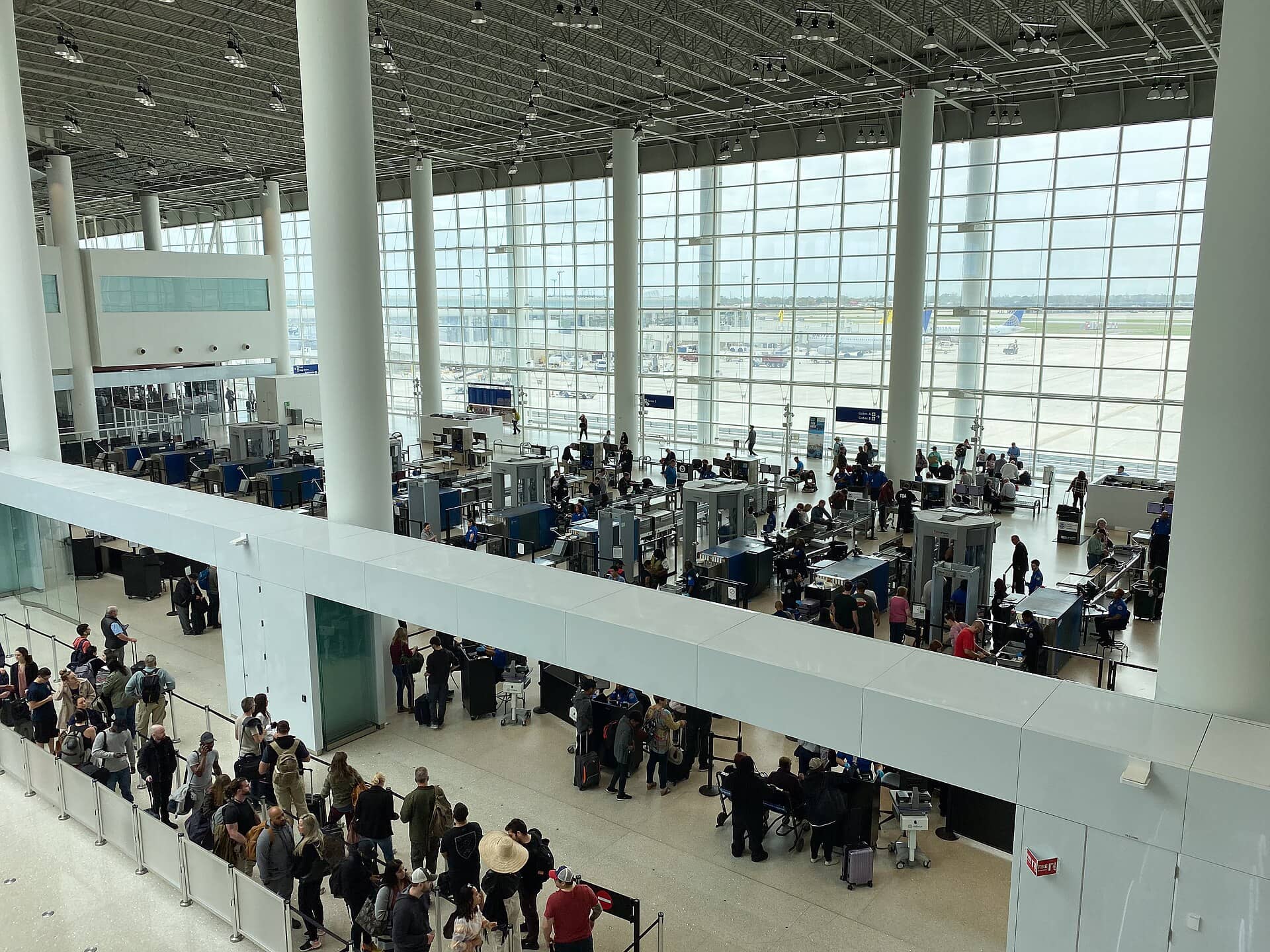 A TSA airport security checkpoint with travelers approaching screening