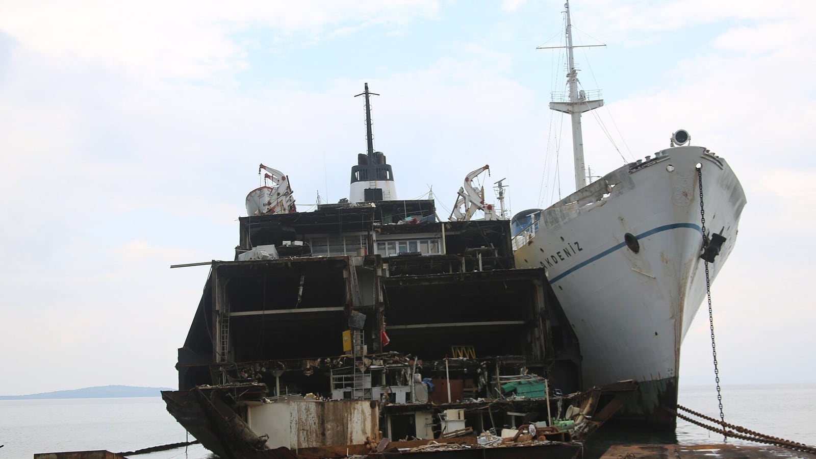 A spectacular view of multiple retired cruise and passenger ships docked and partially dismantled at the industrial Port of Aliağa.