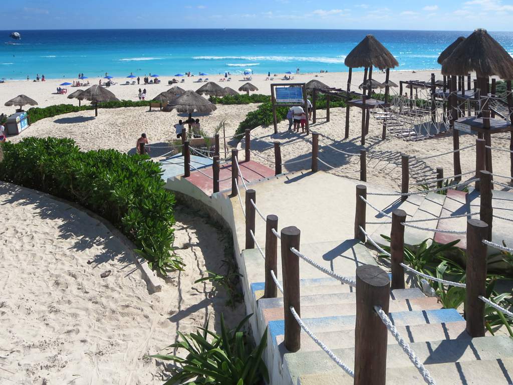 A breathtaking wide view of the turquoise Caribbean sea and white sand beach at Playa Delfines in the Cancun Hotel Zone