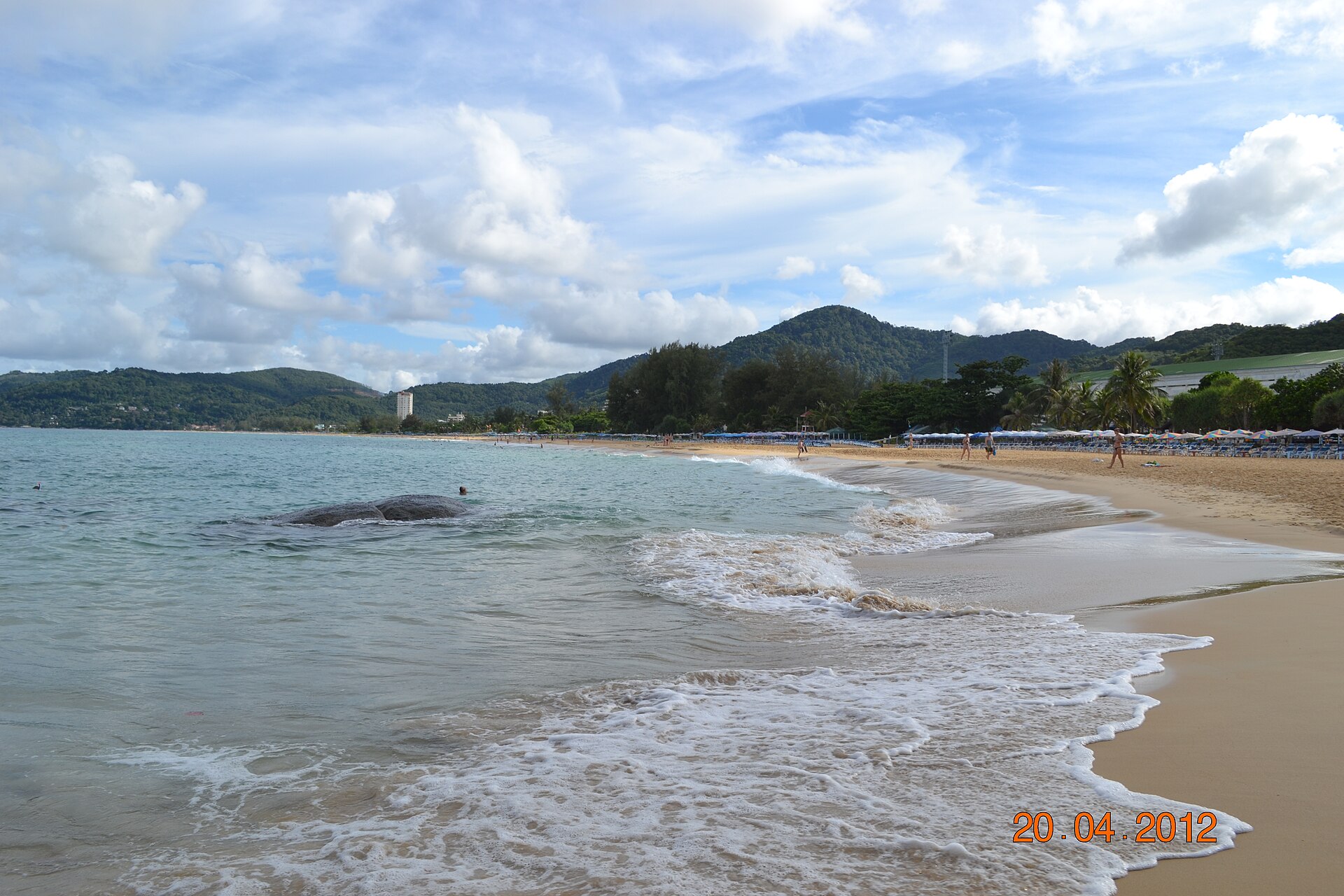 A tropical beach with clear water and umbrellas