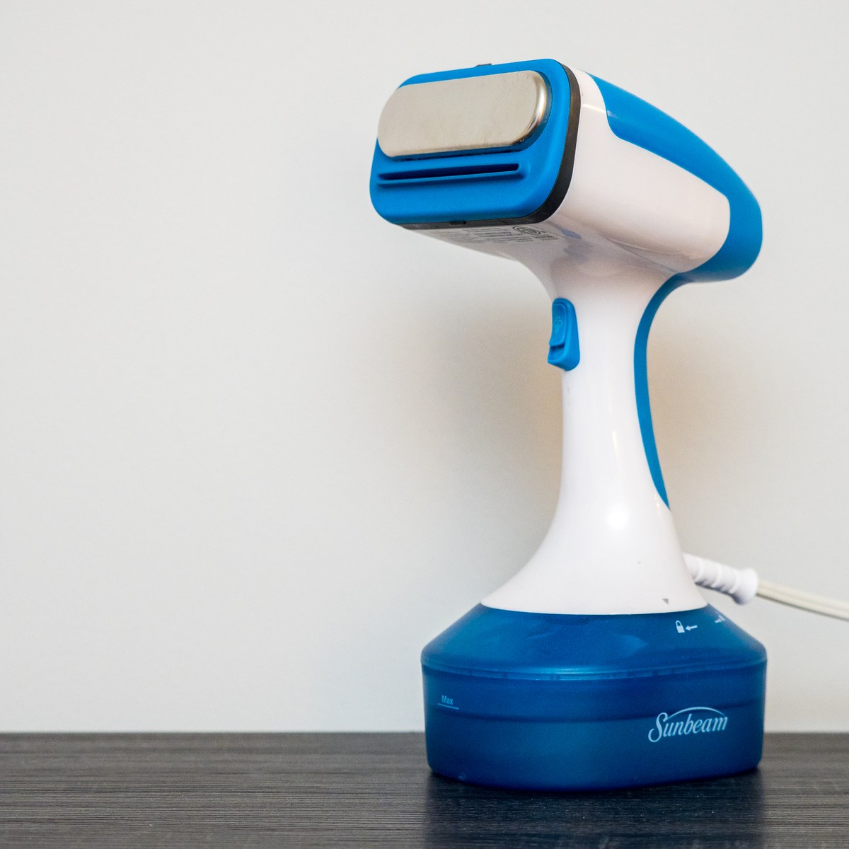 Handheld garment steamer on a table