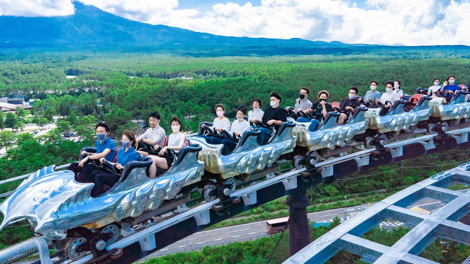Guests riding FUJIYAMA at Fuji-Q Highland with Mount Fuji in the background