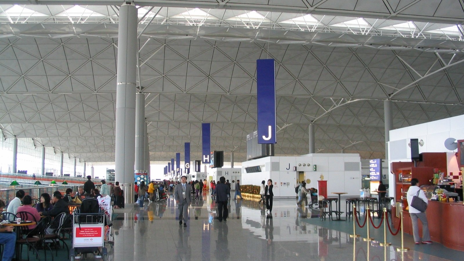 Interior of Hong Kong International Airport Terminal 1 with passengers under the vaulted roof