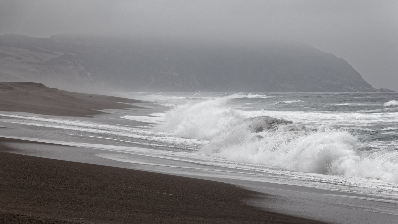 Rocky Pacific shoreline at Point Reyes National Seashore with mussel covered rocks and blue sky