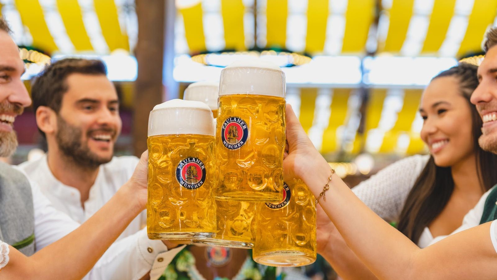 Guests raising large beer mugs in a toast at a Carowinds festival setting