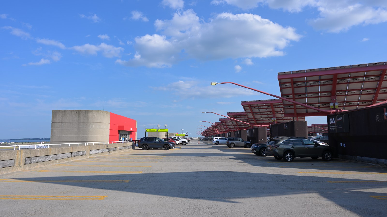Boston Logan Airport Terminal B parking garage roof with solar panels under blue sky