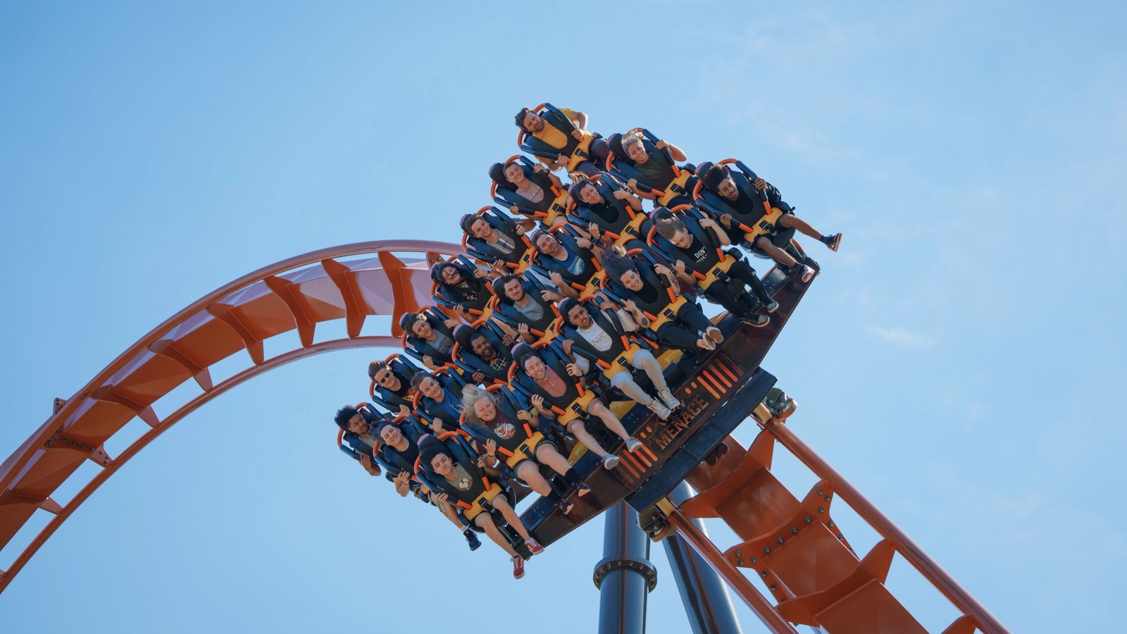 Orange steel roller coaster train cresting a hill against blue sky at Dorney Park
