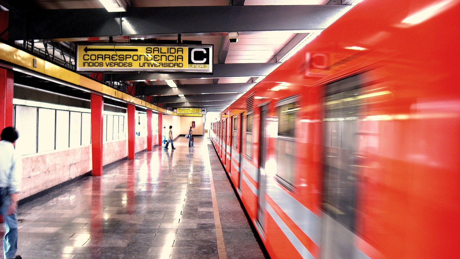 Interior of a New York City subway car with standing and seated passengers