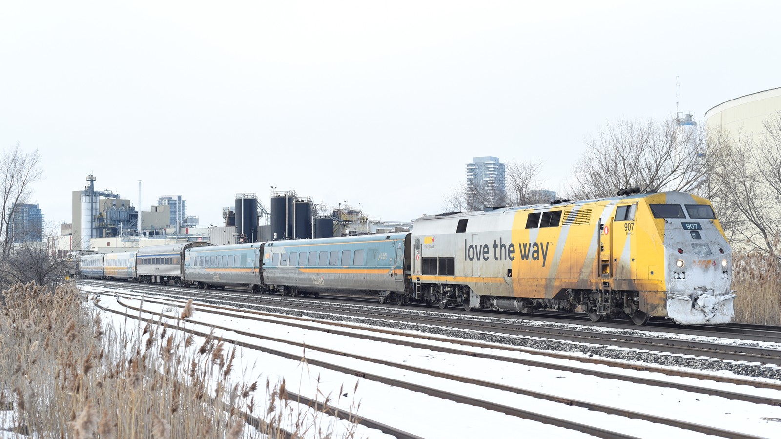 Blue and yellow VIA Rail passenger train at a Canadian station platform