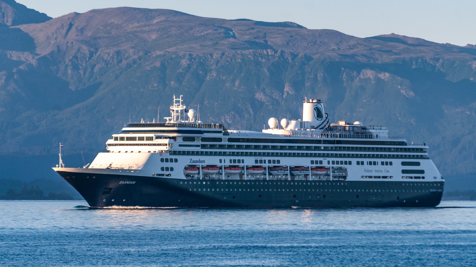 Holland America Zaandam cruise ship sailing off Alaska with mountains behind