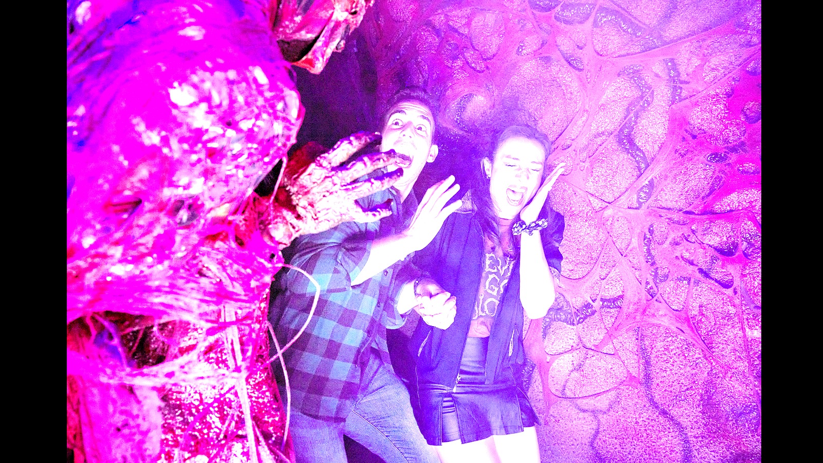 Guests react inside a Halloween Horror Nights haunted house at Universal Orlando Resort