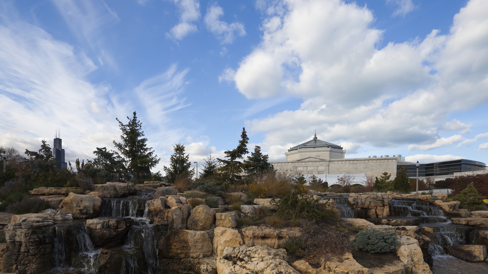 Daytime exterior of Shedd Aquarium on Chicago Museum Campus with gardens and skyline beyond