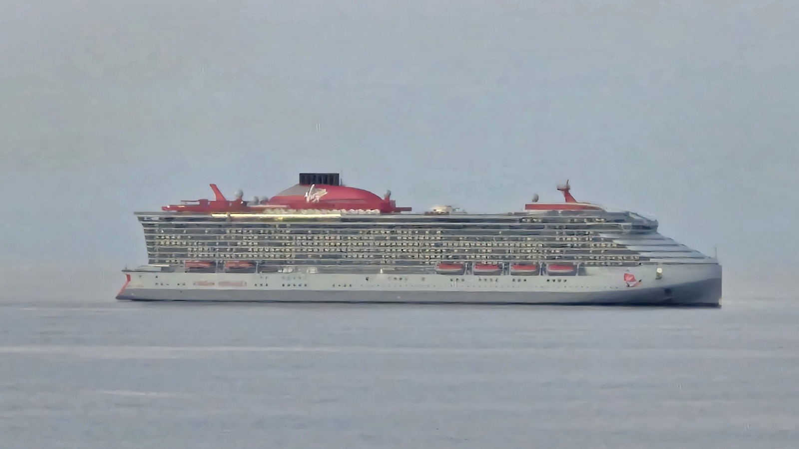Virgin Voyages Brilliant Lady cruise ship profile with red funnel on open water
