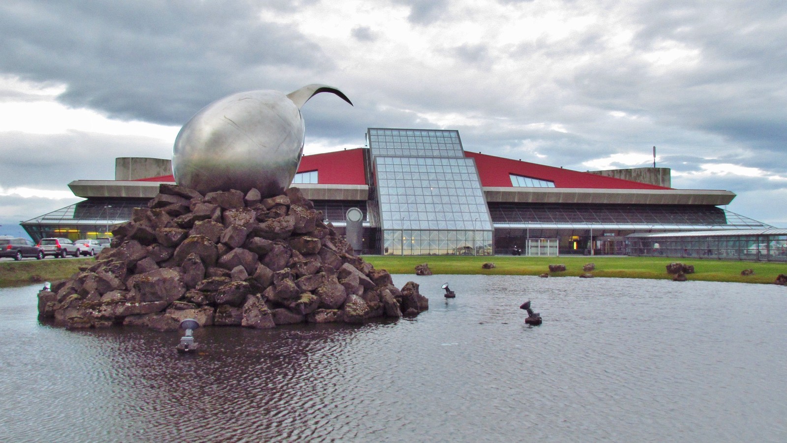 Keflavik International Airport terminal exterior with the Jet Nest sculpture and reflecting pool