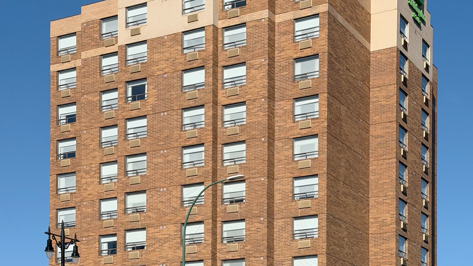 Holiday Inn and Suites high-rise exterior under clear blue sky