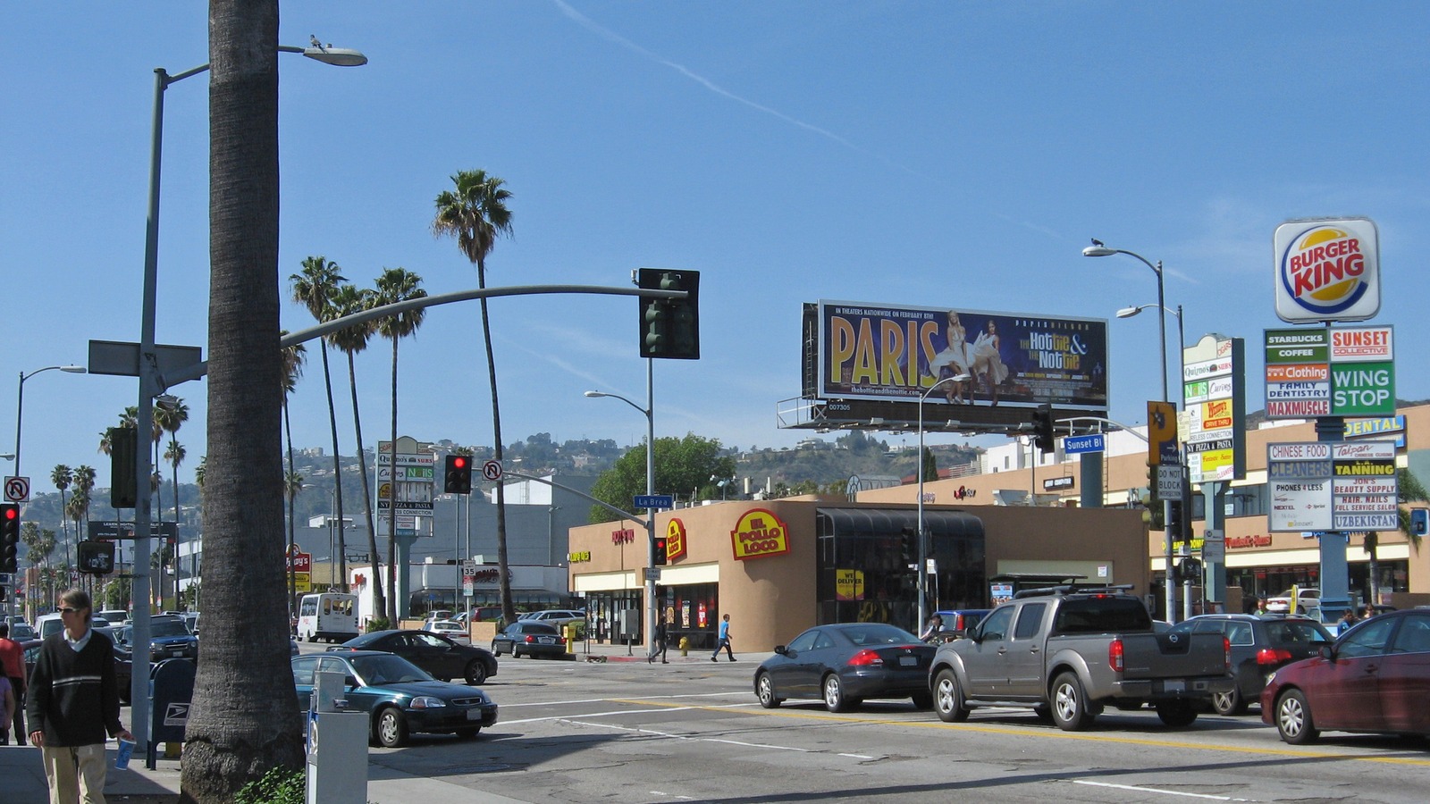 Sunset Boulevard looking west at La Brea Avenue in Los Angeles with street traffic and hills