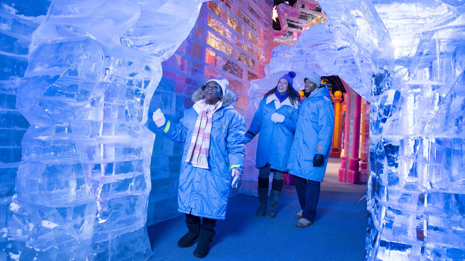 Guests in blue parkas walking among frosty ice structures at Gaylord Pacific ice attraction