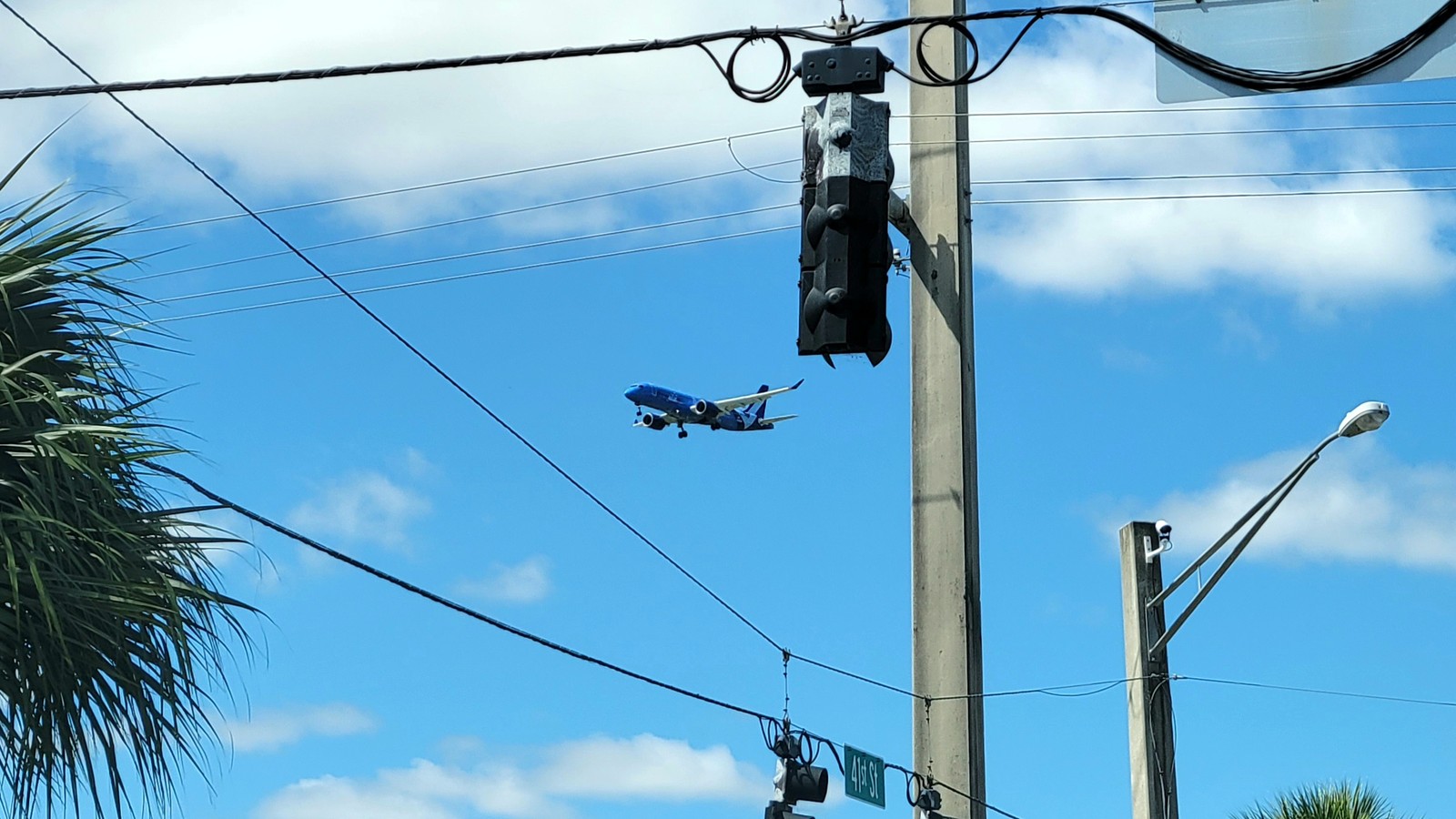 Breeze Airways jet on final approach against a blue sky