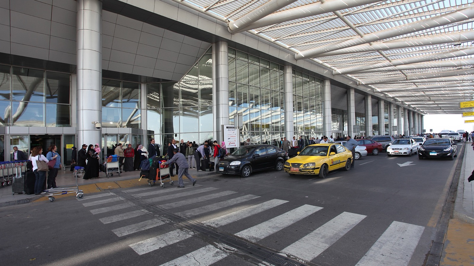 Travelers and vehicles outside Terminal 3 at Cairo International Airport