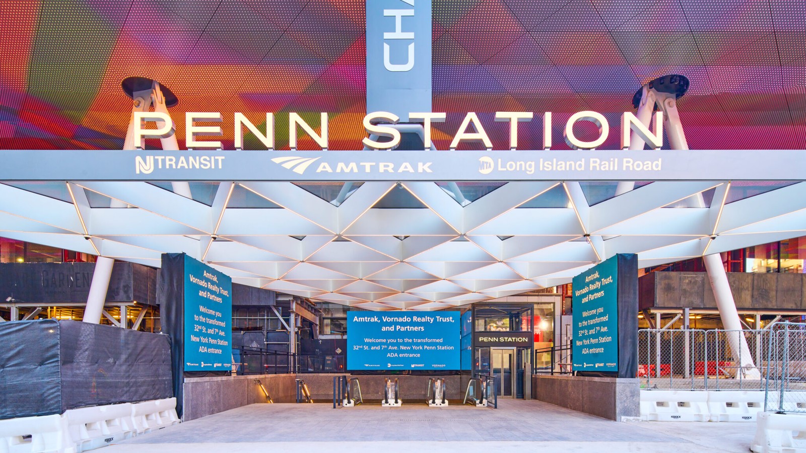 Amtrak New York Penn Station entrance on 32nd Street and Seventh Avenue with pedestrians and station canopy