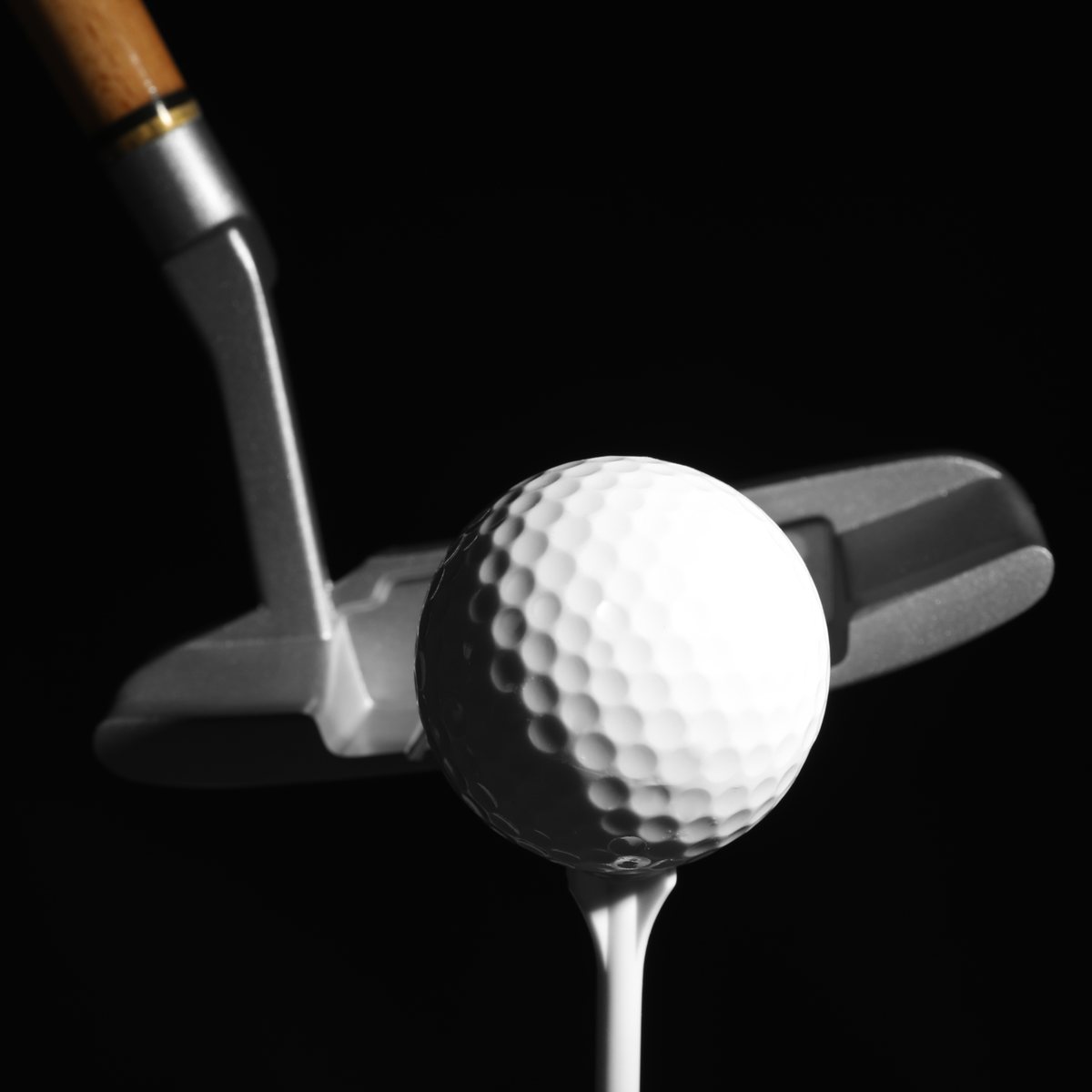 Golf club and ball on a dark background