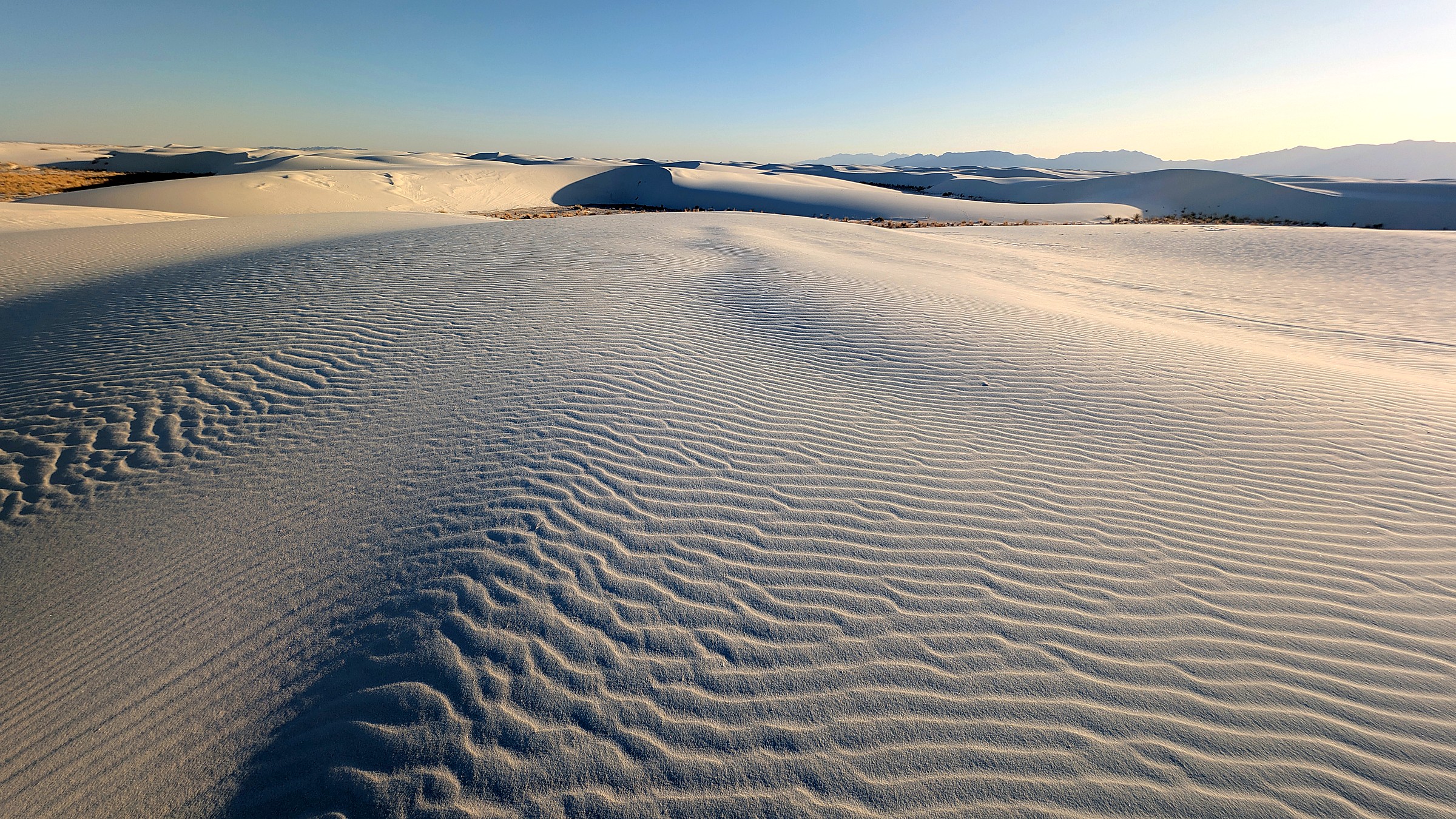 White gypsum dune waves under wide sky at White Sands National Park
