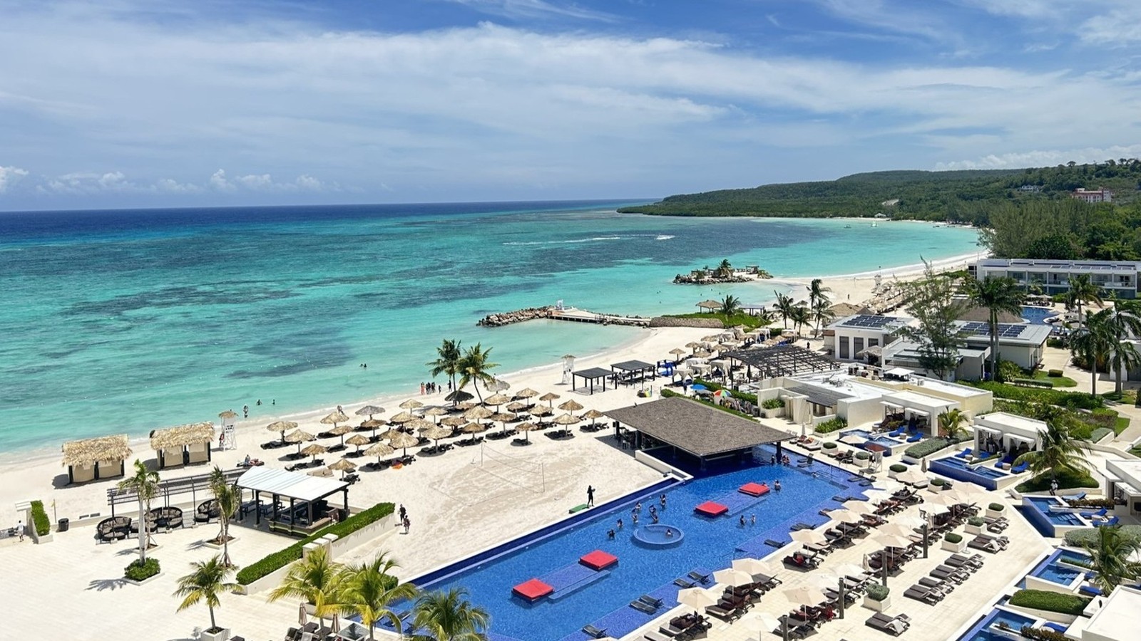 Aerial view of Royalton Blue Waters Montego Bay beach, main pool deck, cabanas, and turquoise coastline