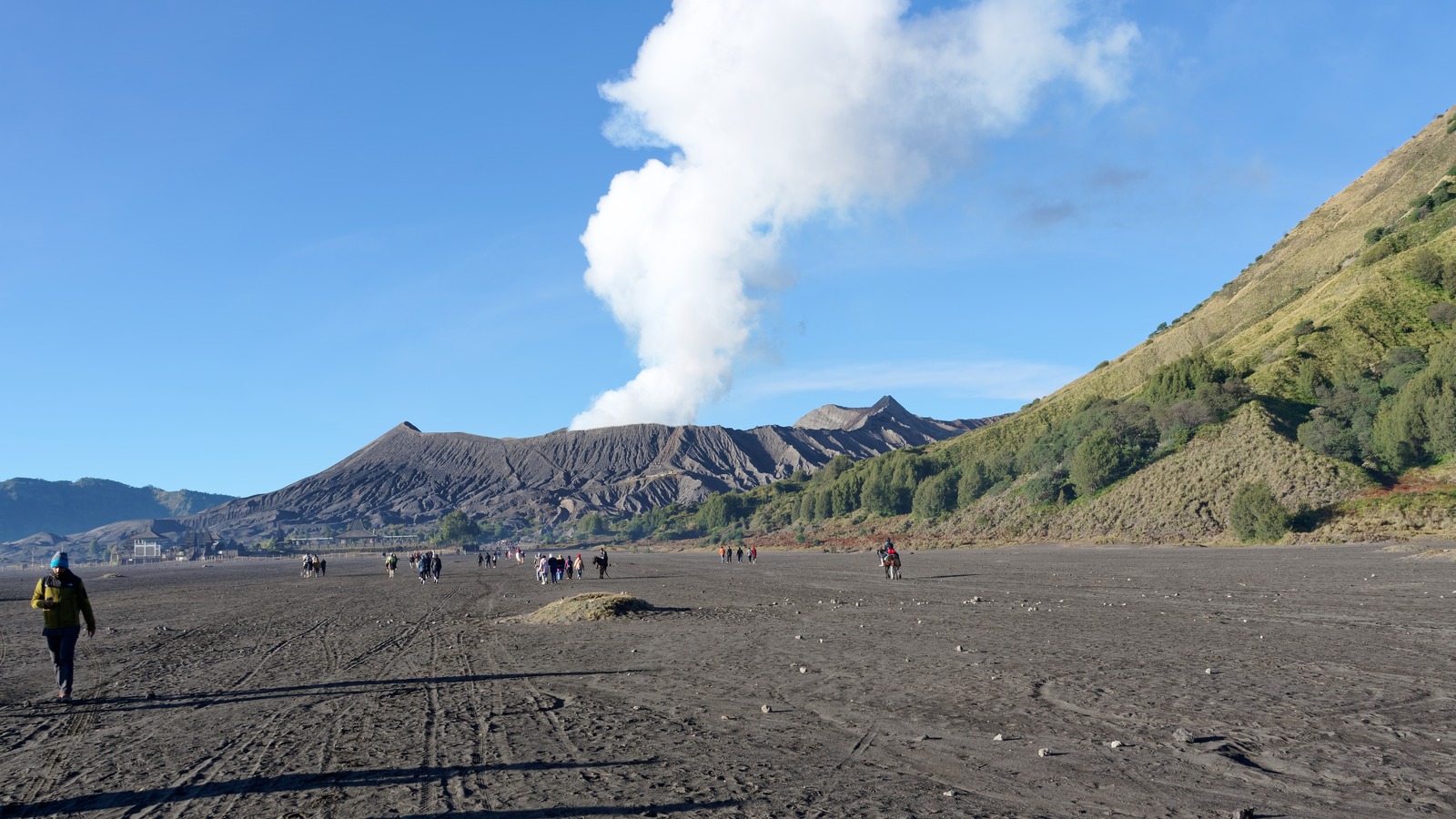 Mount Bromo smoking crater rising from the Sea of Sand with Mount Semeru on the horizon in East Java
