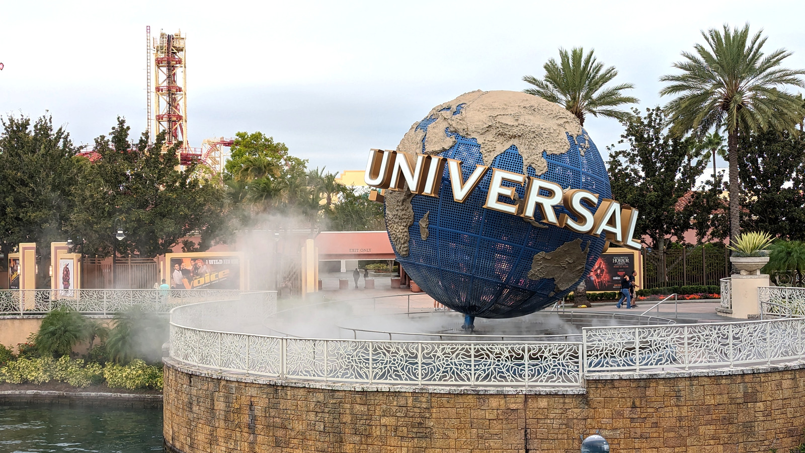Rotating Universal globe and Universal Studios Florida entrance plaza under a blue sky