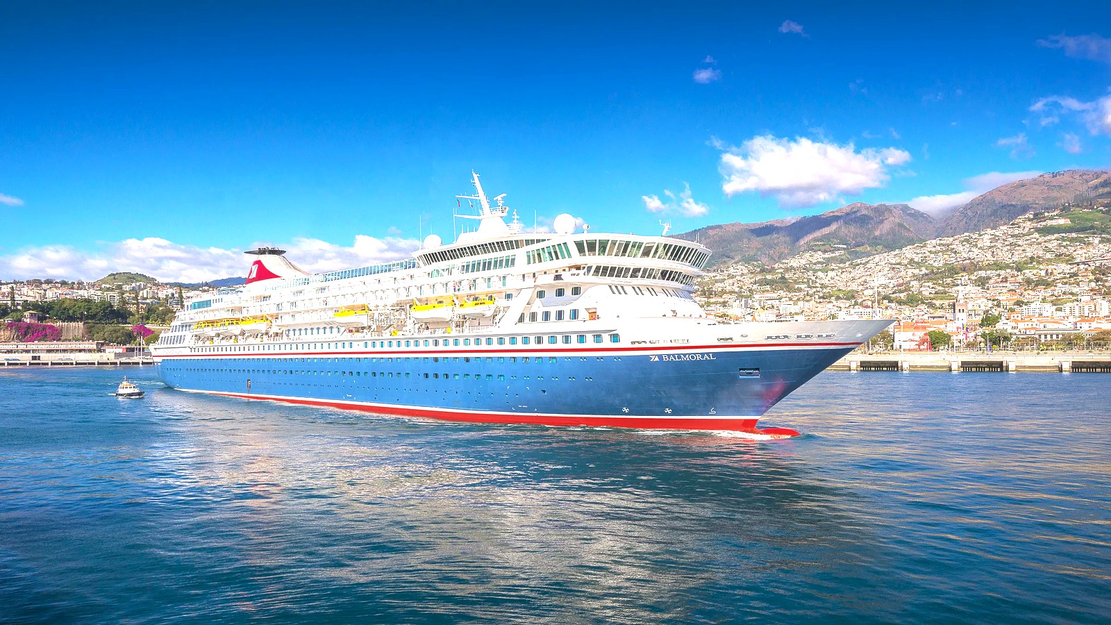 Fred Olsen ship Balmoral docked in Funchal Madeira harbor under blue sky