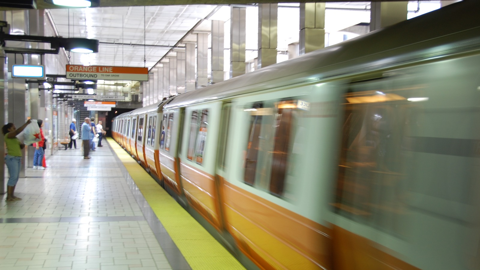MBTA Orange Line subway train arriving on an elevated Boston track under a clear sky