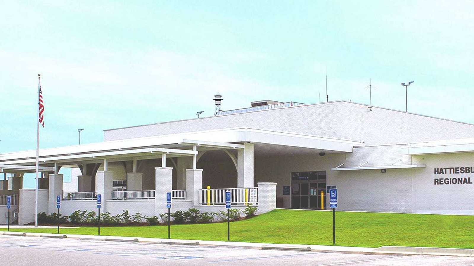 Hattiesburg Regional Airport white terminal exterior with readable wall lettering and flagpole
