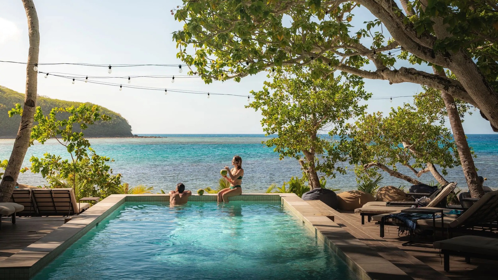 Fiji resort pool overlooking turquoise ocean water and a tropical island