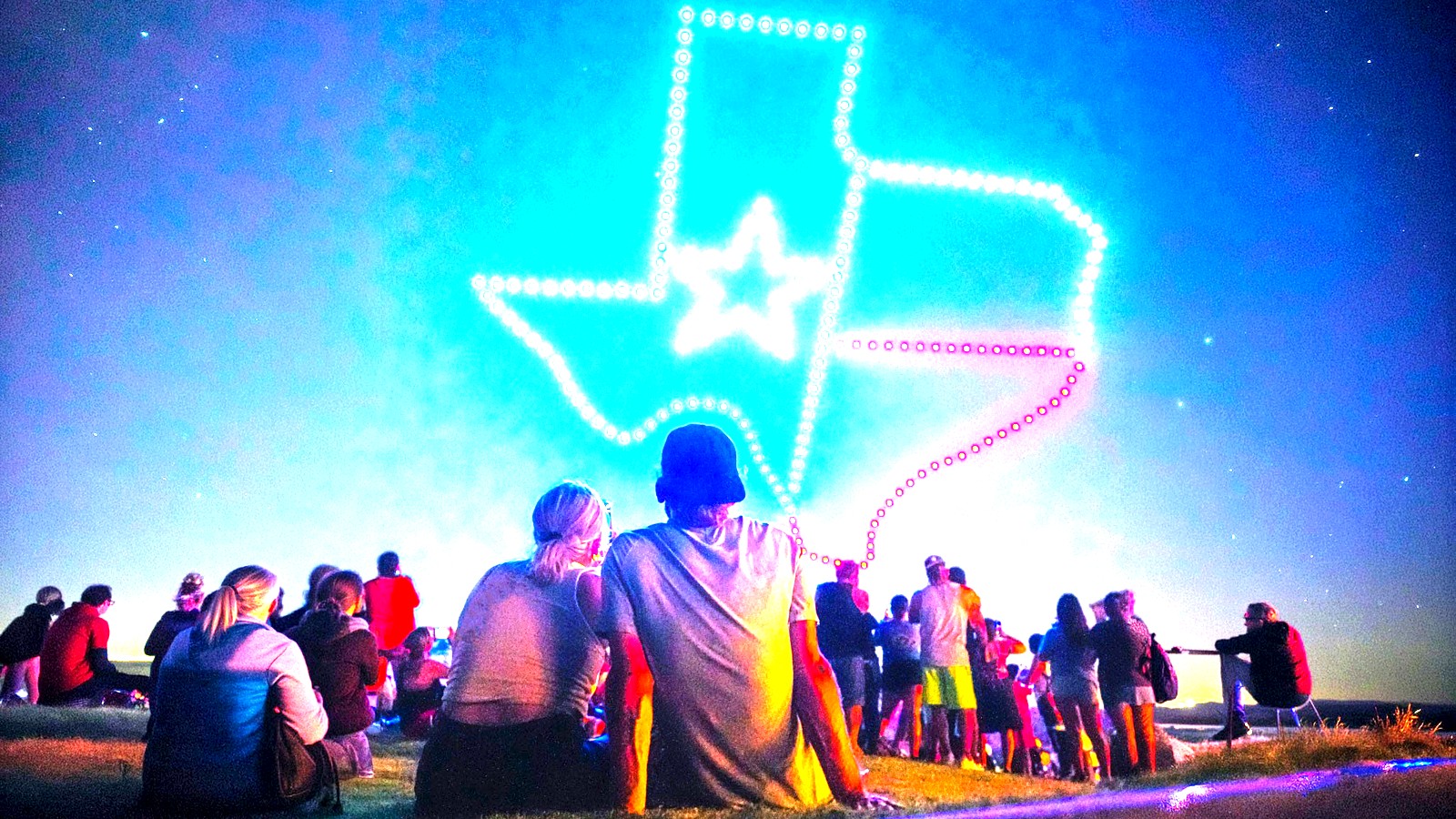 Illuminated FiestaLuz drone formations light the night sky above Six Flags Fiesta Texas