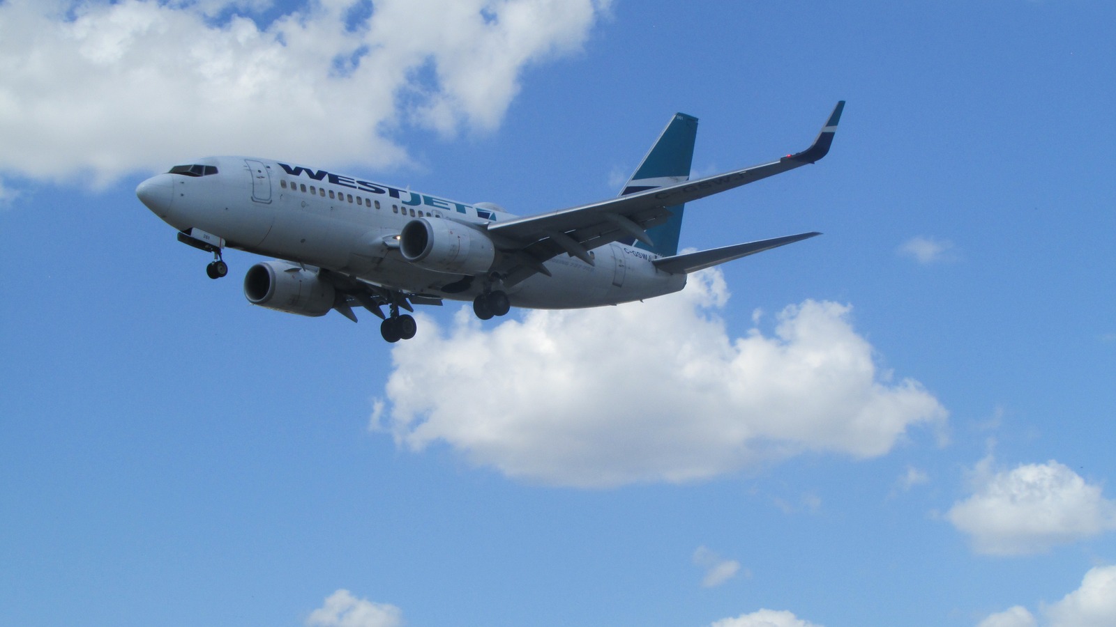 WestJet Boeing 737 on final approach against blue sky