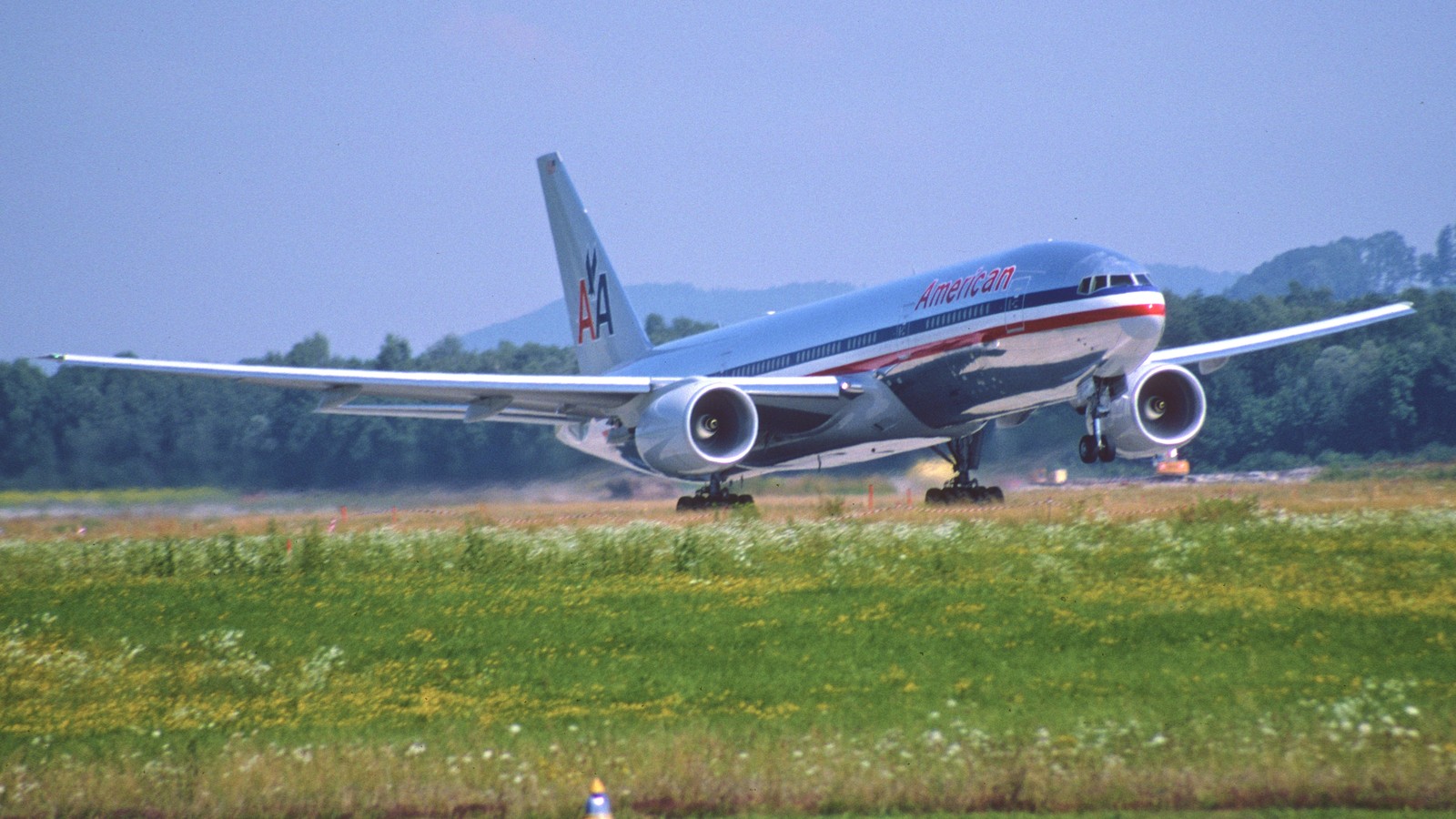 American Airlines Boeing 777 on final approach against blue sky