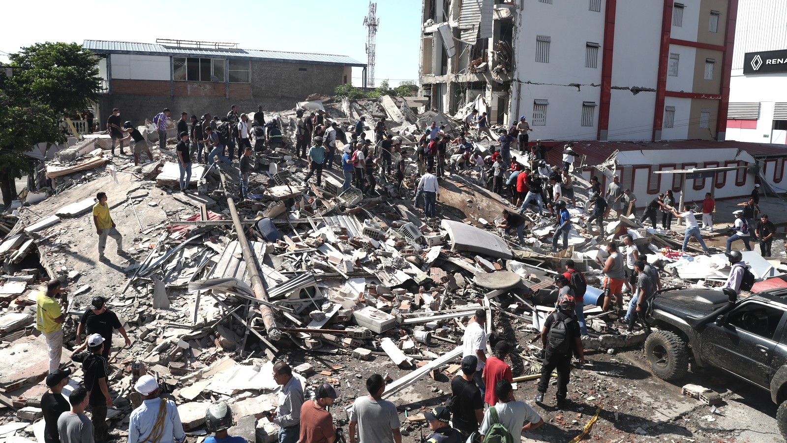 Residents and rescue workers search rubble after the August 10 earthquake in Cali Colombia
