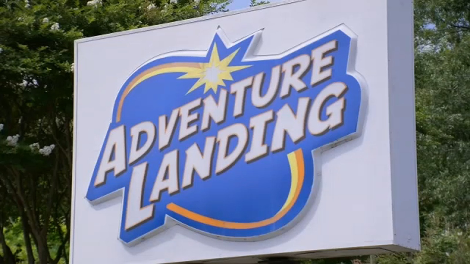 Adventure Landing outdoor park sign with blue logo against trees in Raleigh North Carolina