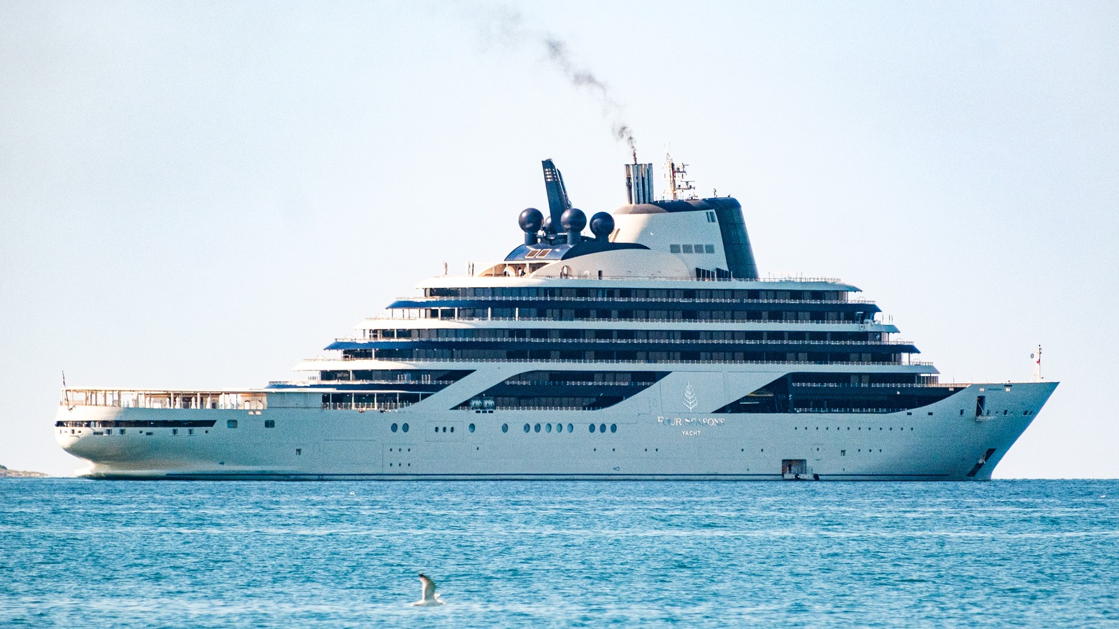 Four Seasons I ultra-luxury yacht underway, showing the white hull and twin glass funnel suites used for the Lanserhof Reset Atlantic crossing.