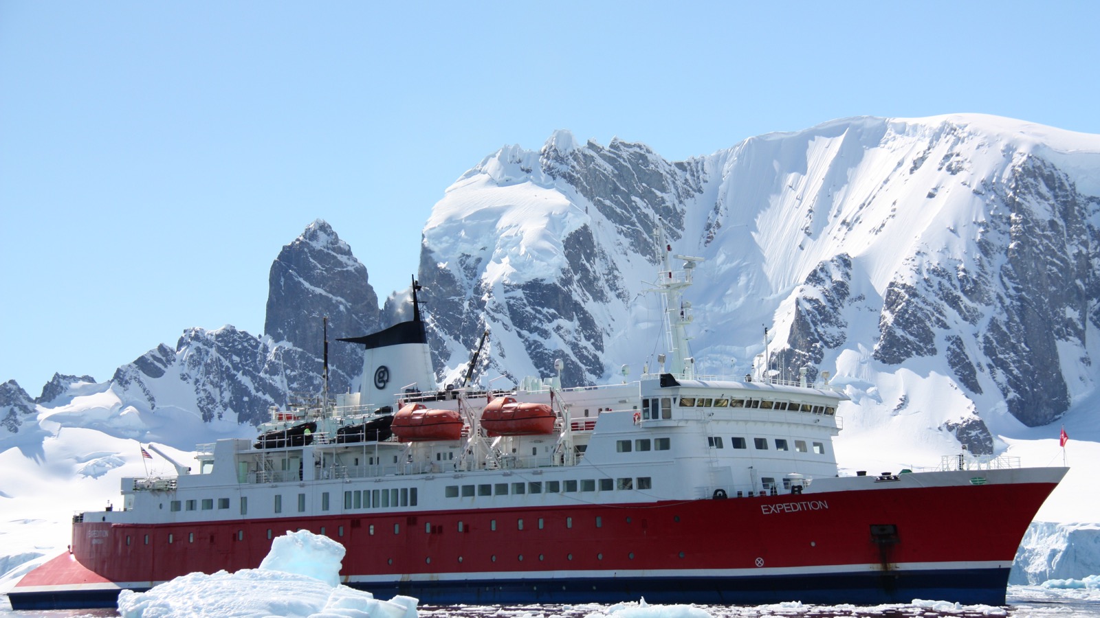 MS Expedition beside snow-covered mountains at Enterprise Island in Antarctica