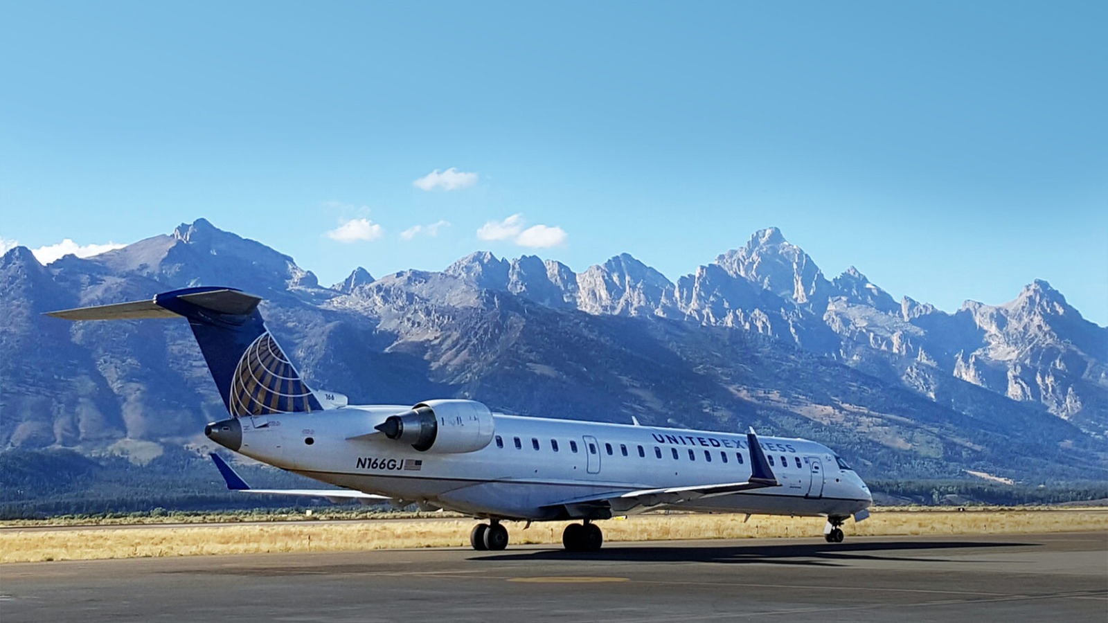 Aerial view of Jackson Hole Airport terminal and runway with the Teton Range in the background