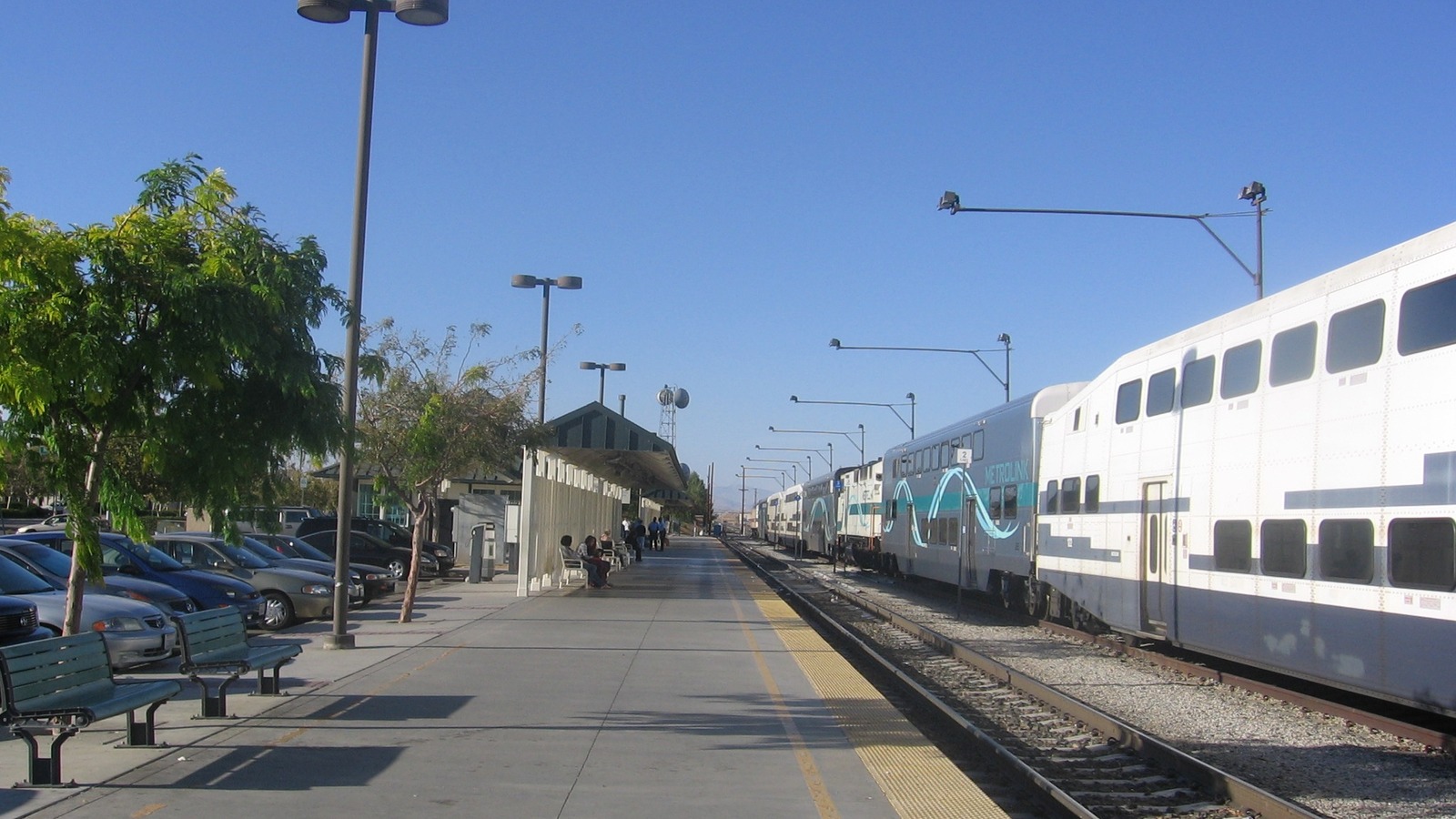 Daylight platform at Lancaster Metrolink station with a Metrolink bilevel train and a readable Metrolink mark