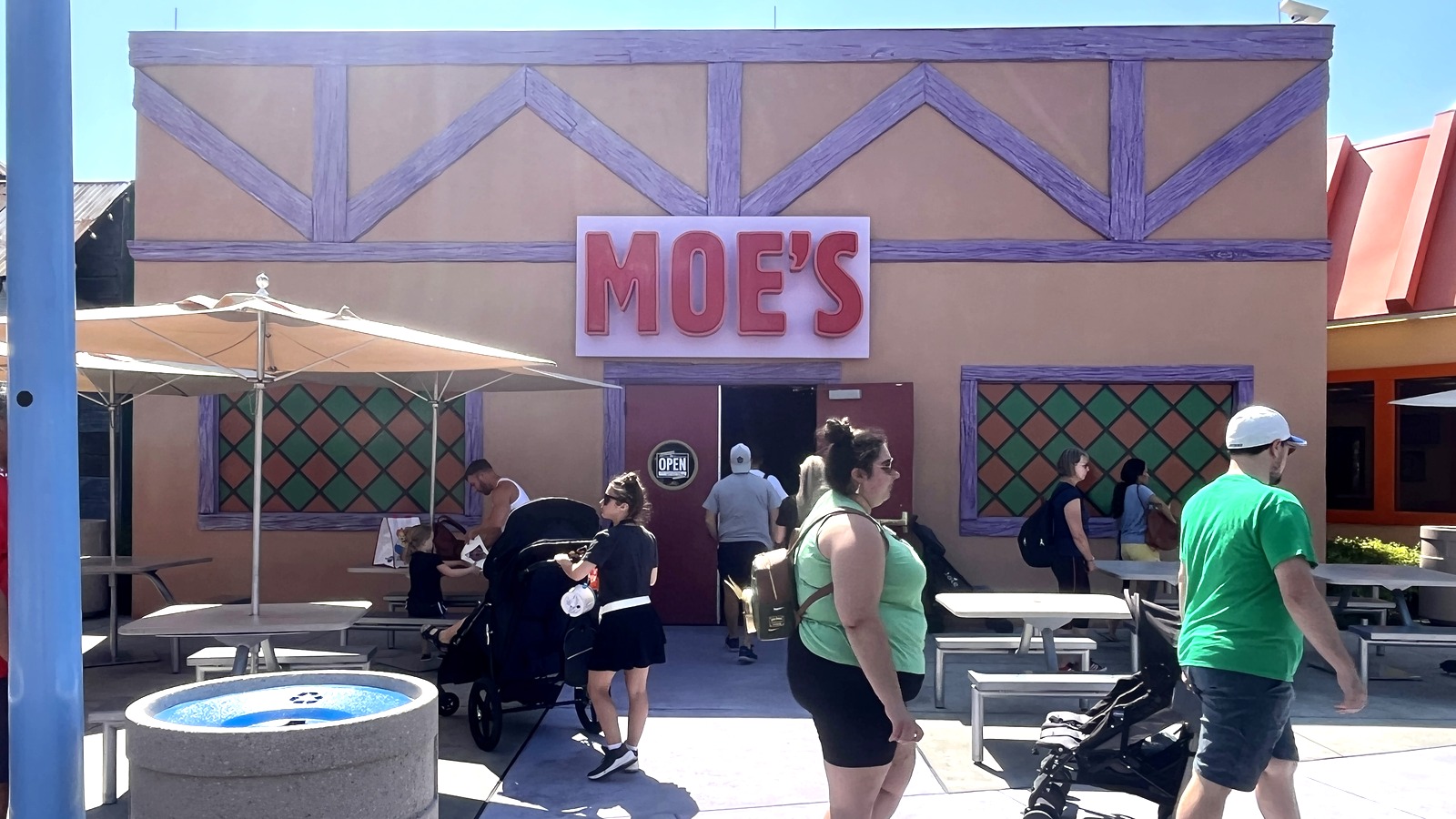 Exterior of Moe's Tavern with neon sign and Simpsons character statues in Springfield at Universal Studios Florida