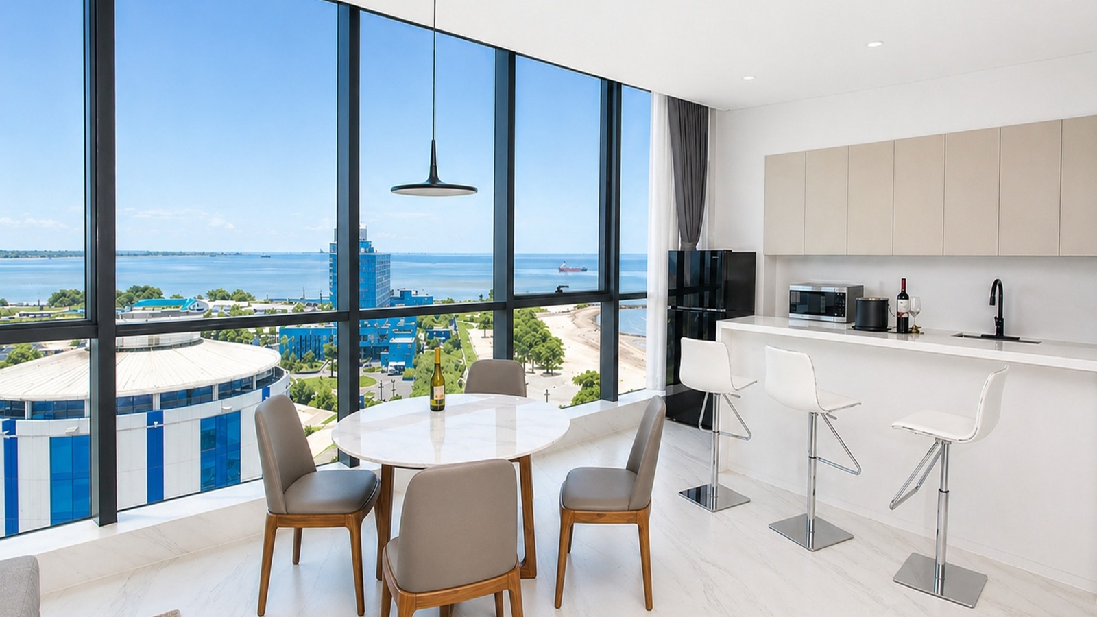 Suite kitchen and living area with floor-to-ceiling windows overlooking the Atlantic Ocean at Atlantic Suites Hotel in Georgetown, Guyana